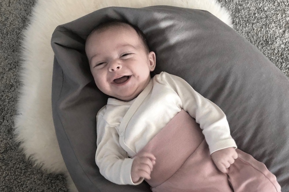 Baby auf einem Stillkissen liegend